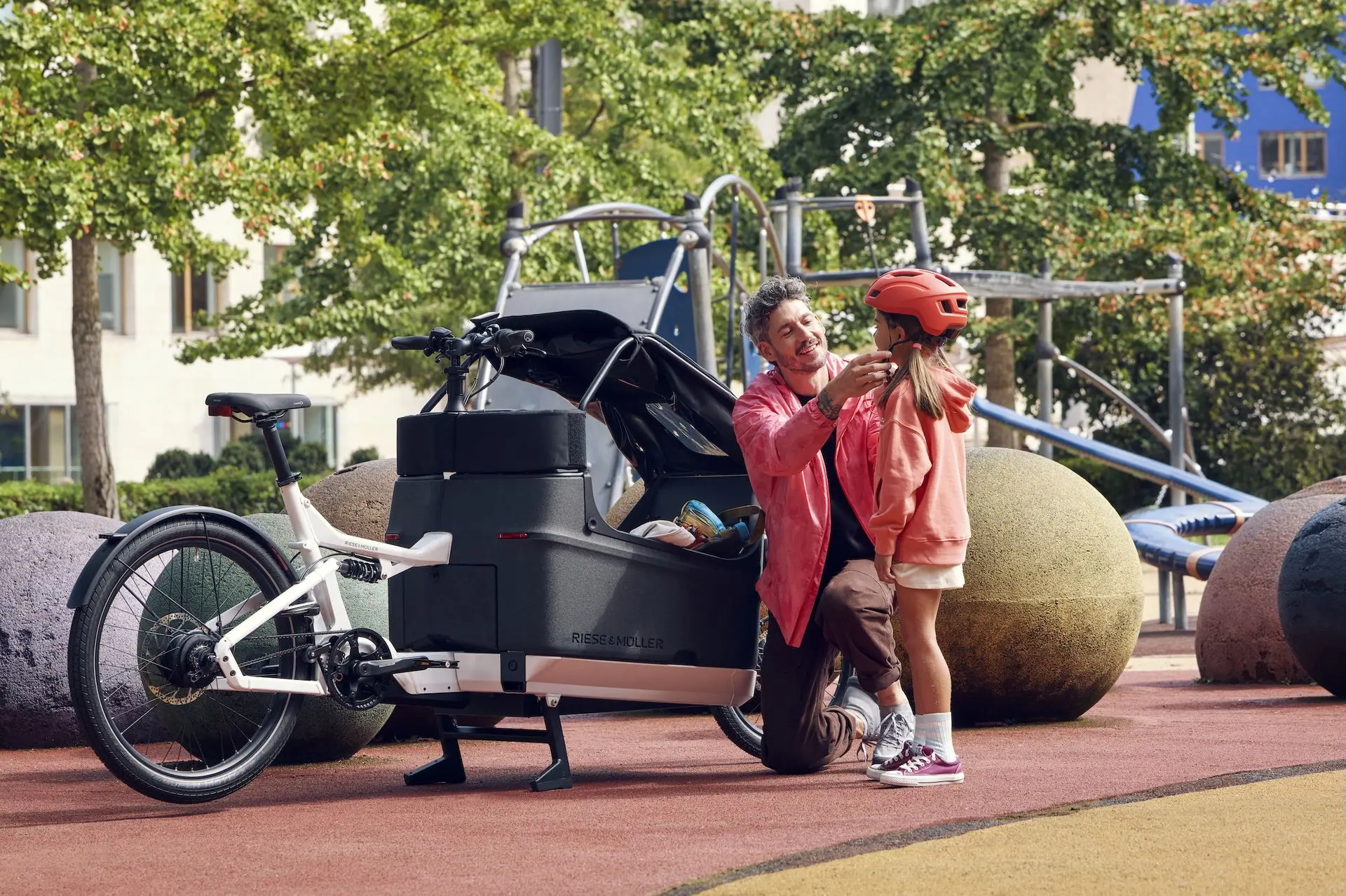 Lastenrad-Werkstatt für Familienräder: Inspektion, Reparatur & Sofort-Service bei Velogold Vater mit Kind und Lastenrad vor der Velogold Werkstatt – unterwegs im Alltag